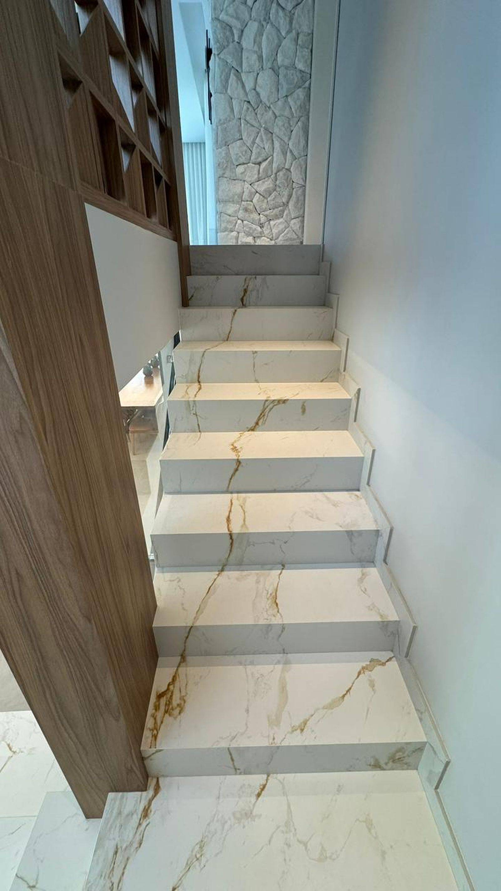 Escada revestida em porcelanato com veios contínuos.